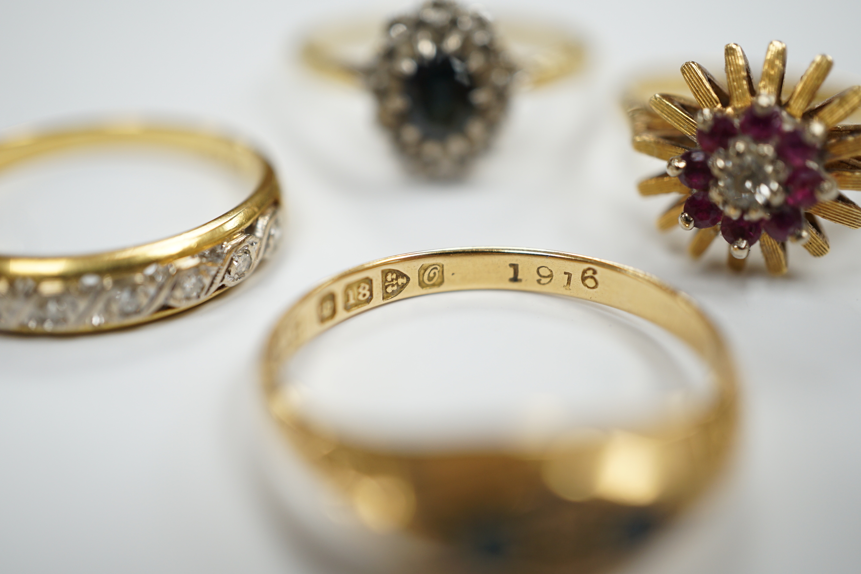 Four assorted Edwardian and later 18ct and gem set rings, including sapphire and diamond chip, size O, gross weight 12.1 grams.